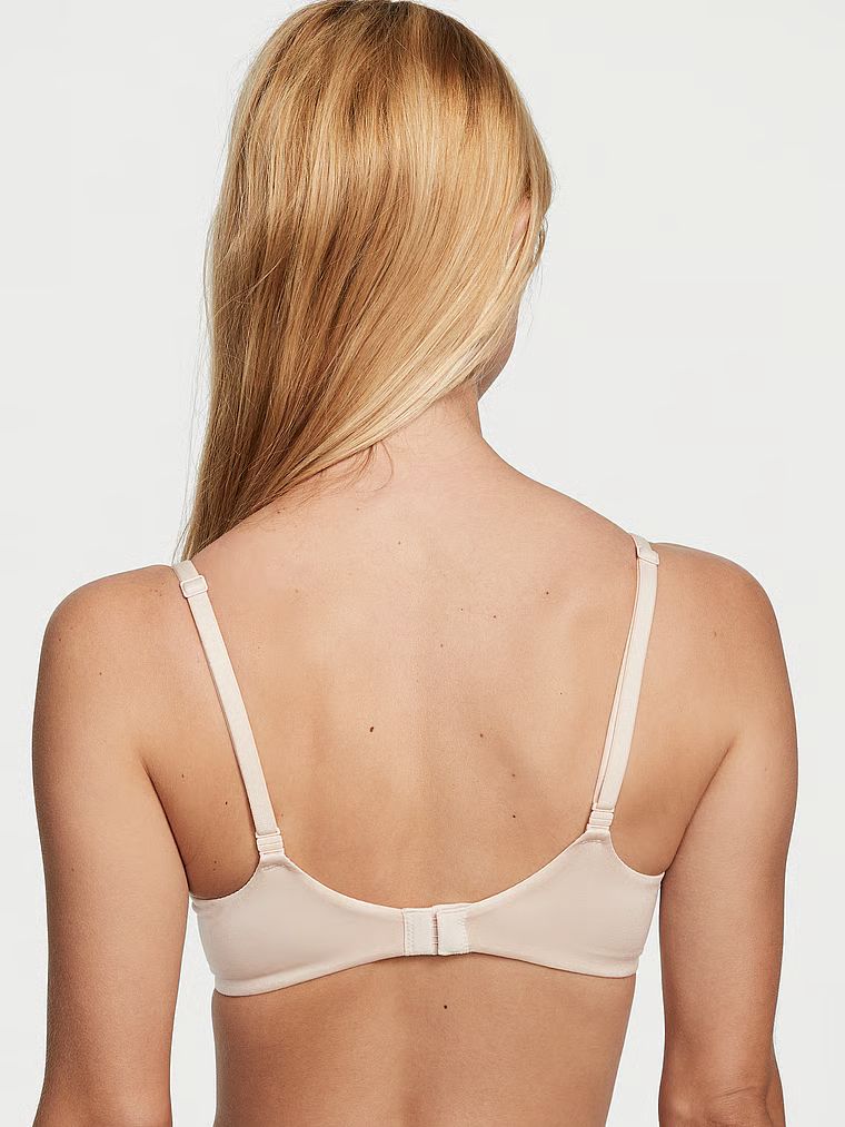 Modelka prezentuje biustonosz lekko usztywniany Smooth Demi. Produkt ma kolor beżowy i pochodzi z kolekcji Body by Victoria.
