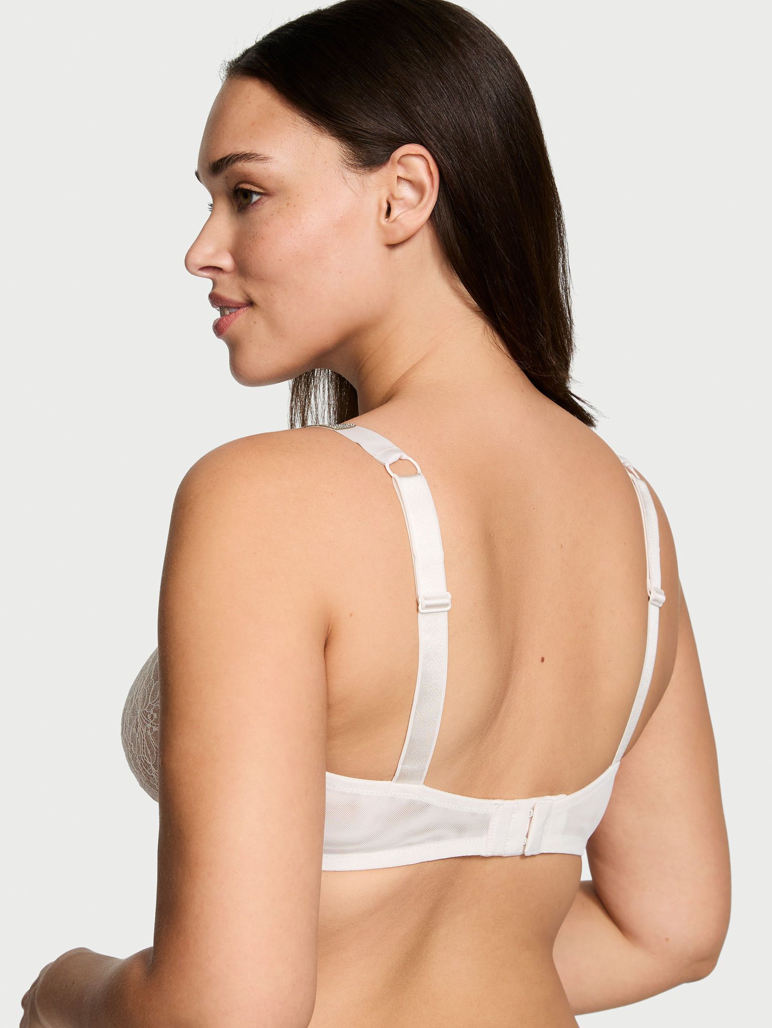 Modelka prezentuje biustonosz nieusztywniany koronkowy z błyszczącymi ramiączkami Shine Strap Demi. Produkt ma kolor biały i pochodzi z kolekcji Very Sexy.