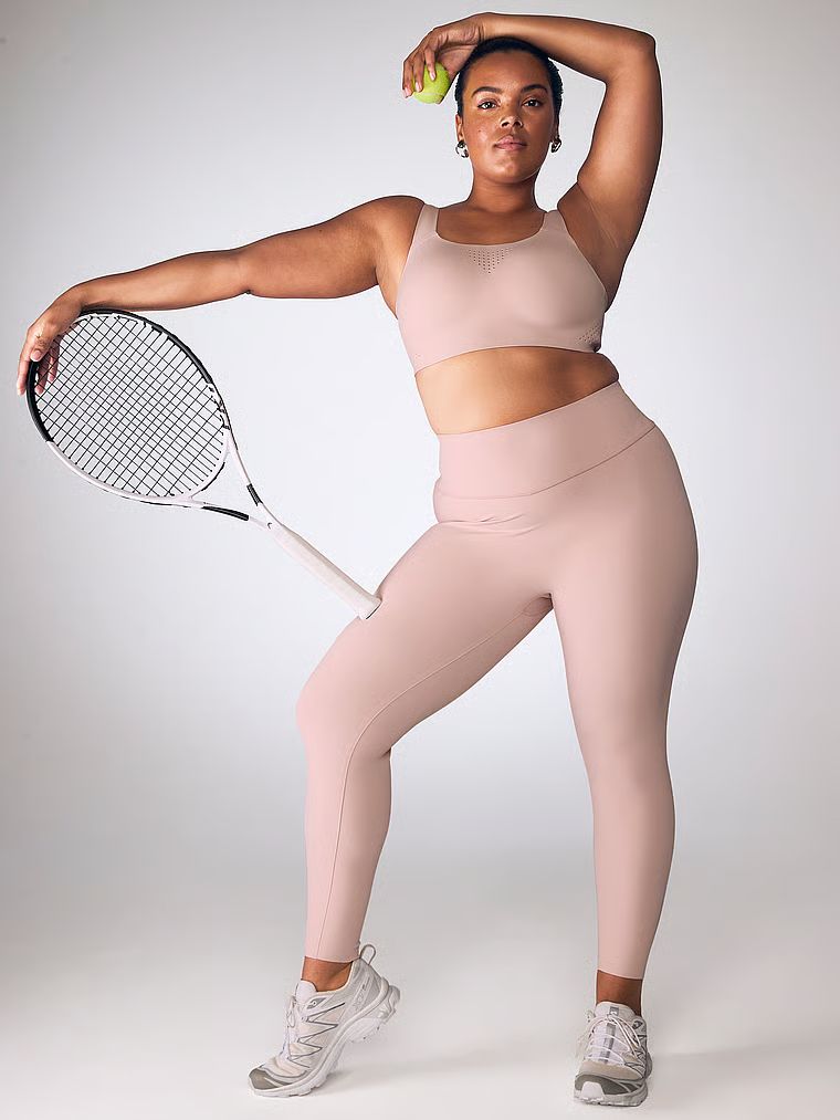 Modelka prezentuje biustonosz sportowy z maksymalnym podtrzymaniem Featherweight Max. Produkt ma kolor beżowy i pochodzi z kolekcji VSX.