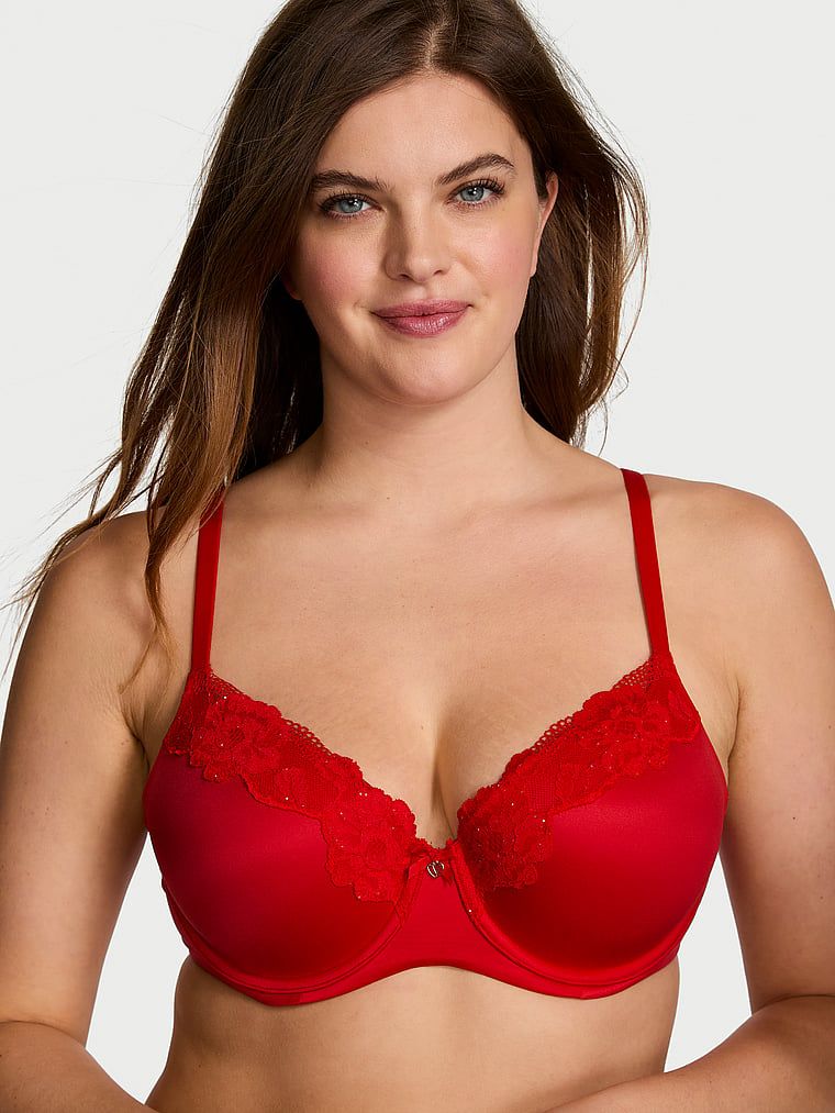 Modelka prezentuje biustonosz lekko usztywniany z koronką Demi. Produkt ma kolor czerwony i pochodzi z kolekcji Body by Victoria.