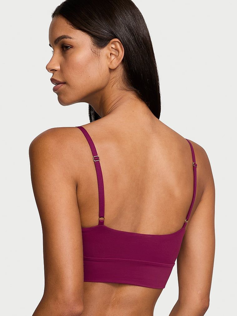 Modelka prezentuje biustonosz braletka Feathersoft Essentials. Produkt ma kolor czerwony i pochodzi z kolekcji Victoria's Secret.