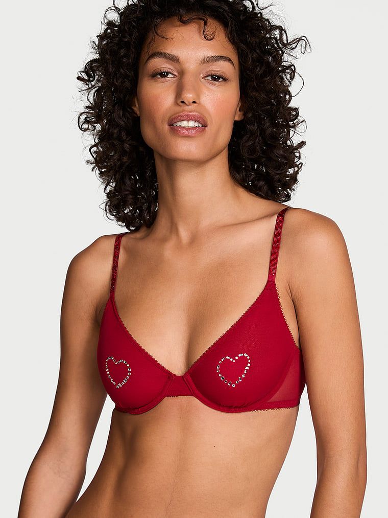 Modelka prezentuje biustonosz nieusztywniany Sheer Shine Demi. Produkt ma kolor czerwony i pochodzi z kolekcji Very Sexy.