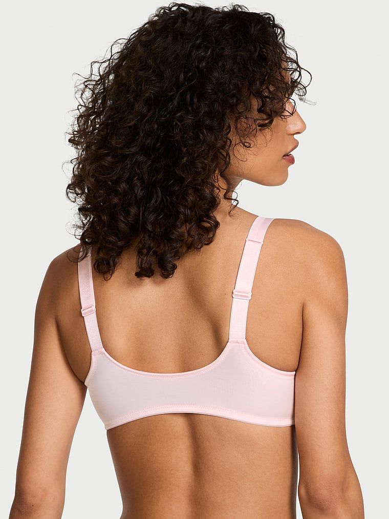 Modelka prezentuje biustonosz braletka bez fiszbin z błyszczącymi ramiączkami Shine Strap. Produkt ma kolor różowy i pochodzi z kolekcji Very Sexy.