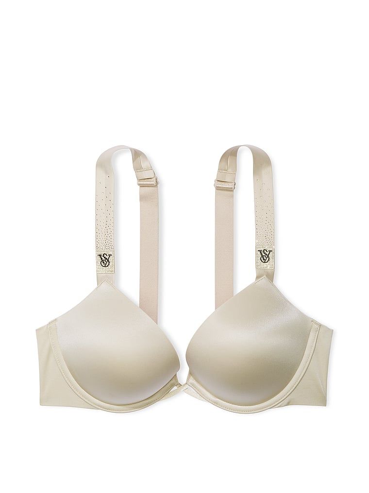 Na zdjęciu na białym tle widoczny jest biustonosz push-up powiększający o 2 rozmiary Bombshell Scattered Shine Strap. Produkt ma kolor beżowy i pochodzi z kolekcji Very Sexy.