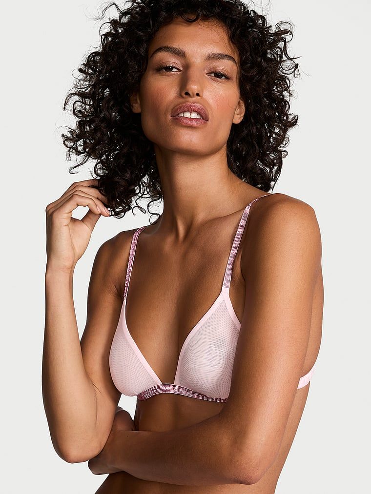Modelka prezentuje biustonosz braletka z błyszczącymi ramiączkami i obwodem Sheer Shine. Produkt ma kolor różowy i pochodzi z kolekcji Very Sexy.