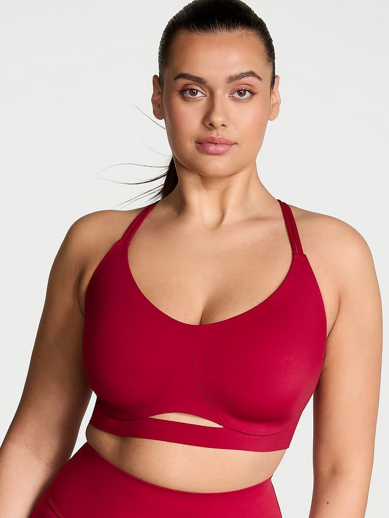 Modelka prezentuje biustonosz sportowy z lekkim wsparciem Elevate Strappy. Produkt ma kolor czerwony i pochodzi z kolekcji VSX.