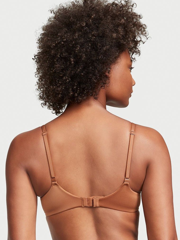 Modelka prezentuje biustonosz lekko usztywniany Smooth Demi. Produkt ma kolor brązowy i pochodzi z kolekcji Body by Victoria.