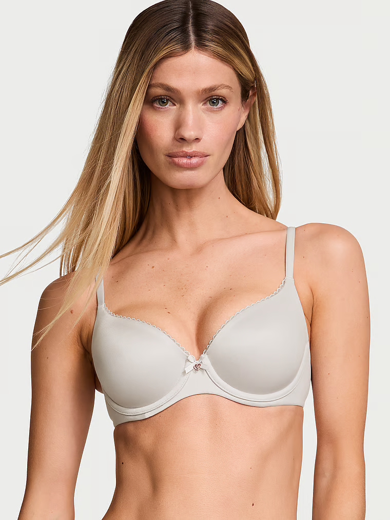 Modelka prezentuje biustonosz lekko usztywniany Smooth Demi. Produkt ma kolor szary i pochodzi z kolekcji Body by Victoria.