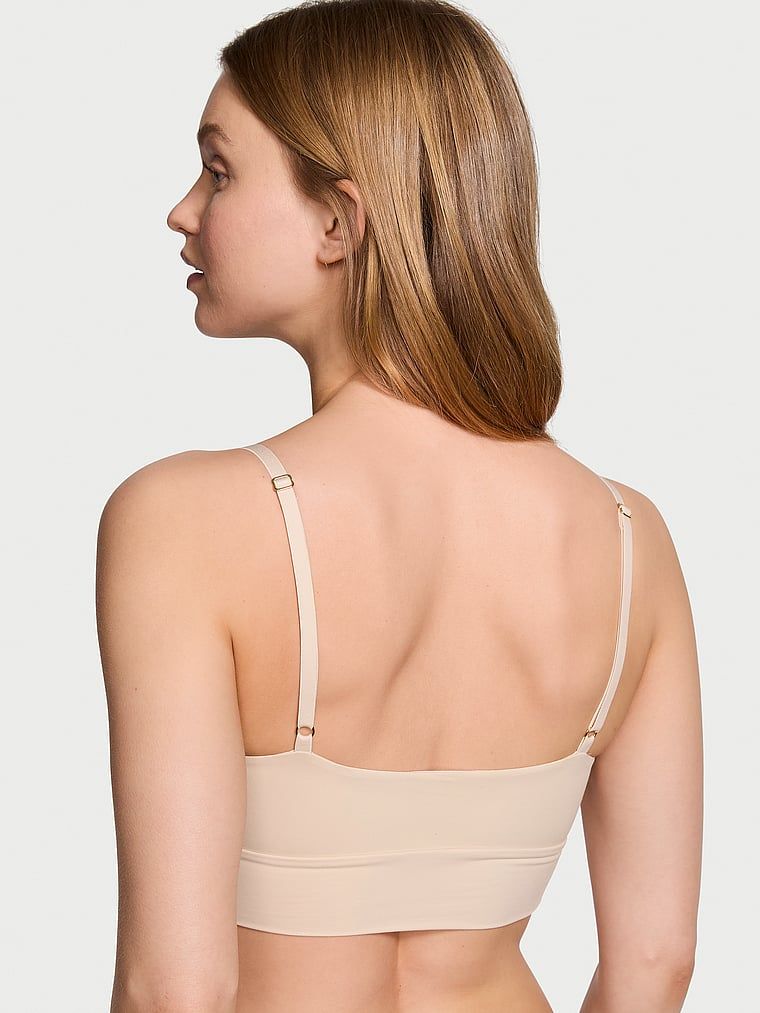 Modelka prezentuje biustonosz braletka Feathersoft Essentials. Produkt ma kolor beżowy i pochodzi z kolekcji Victoria's Secret.