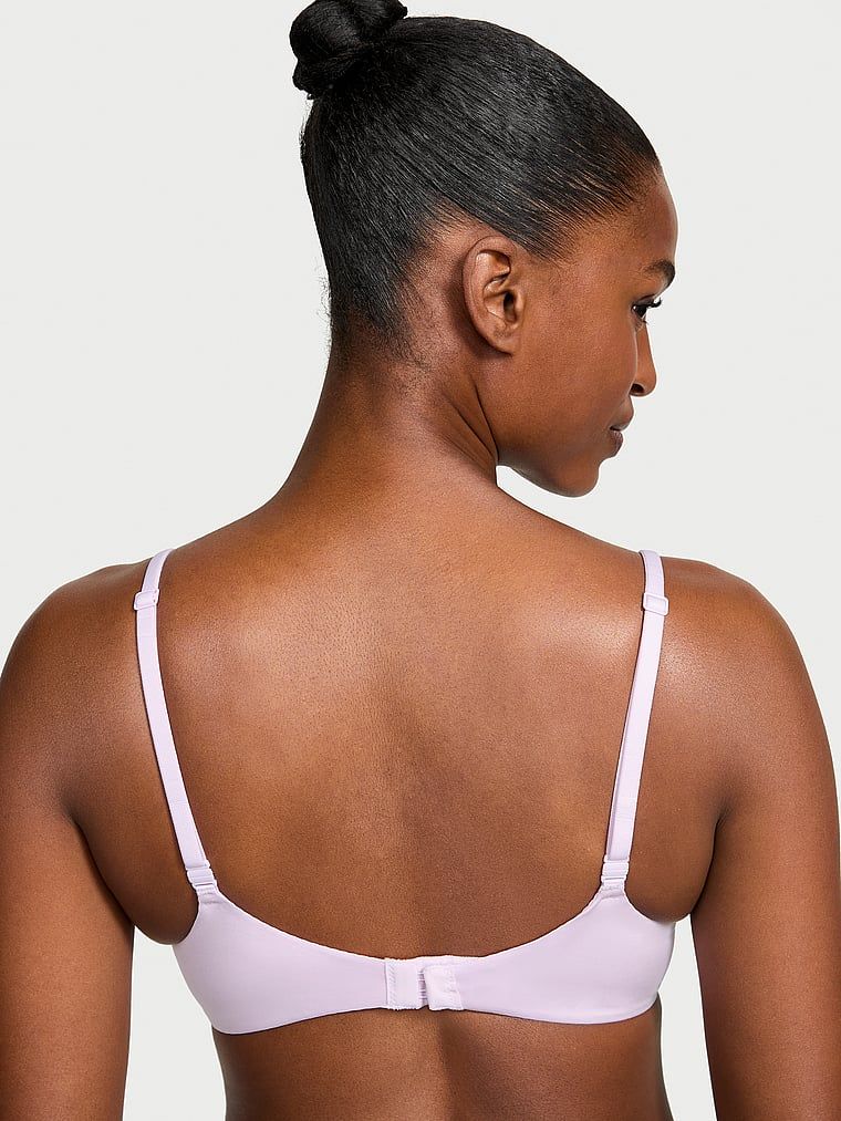 Modelka prezentuje biustonosz nieusztywniany Invisible Lift Smooth Demi. Produkt ma kolor purpurowy i pochodzi z kolekcji Body by Victoria.