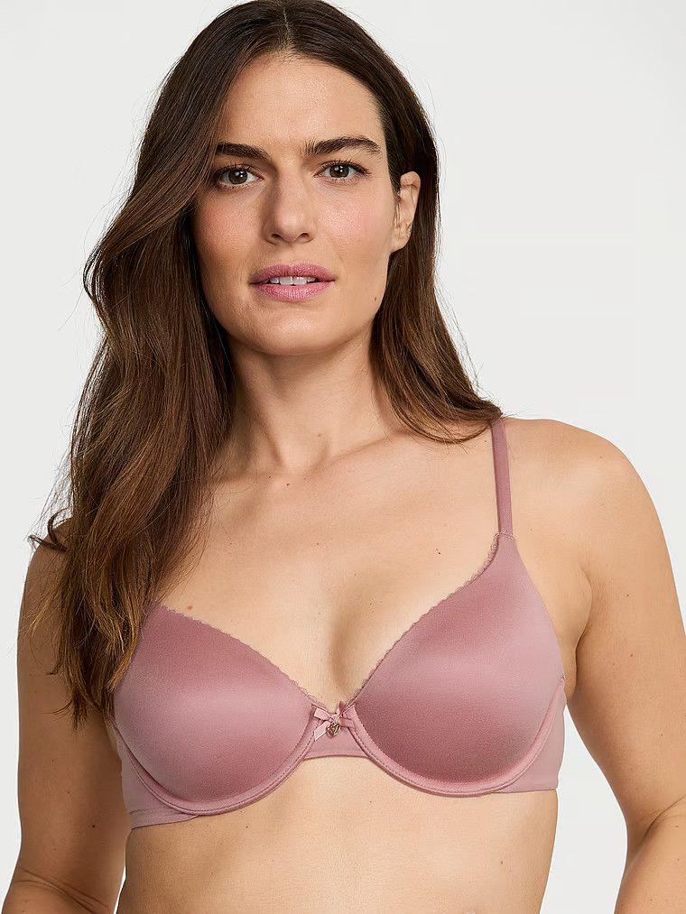 Modelka prezentuje biustonosz lekko usztywniany z mocno zabudowanymi miseczkami. Produkt ma kolor różowy i pochodzi z kolekcji Body by Victoria.
