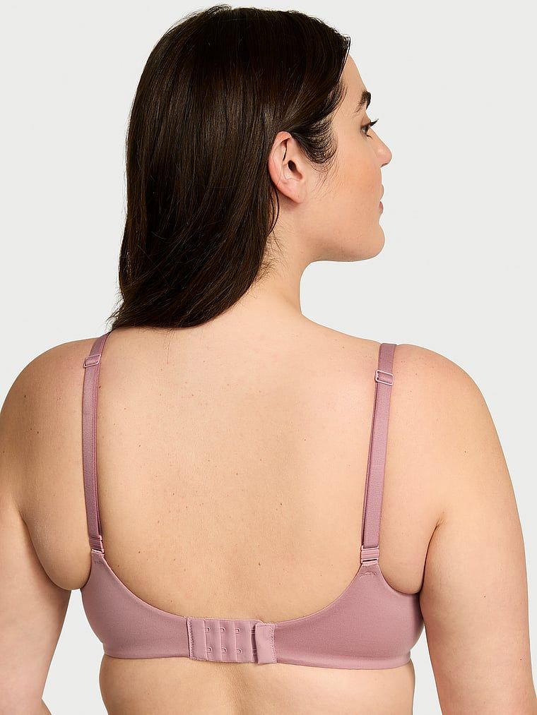 Modelka prezentuje biustonosz zmniejszający optycznie biust Invisible Lift Minimizer. Produkt ma kolor różowy i pochodzi z kolekcji Body by Victoria.