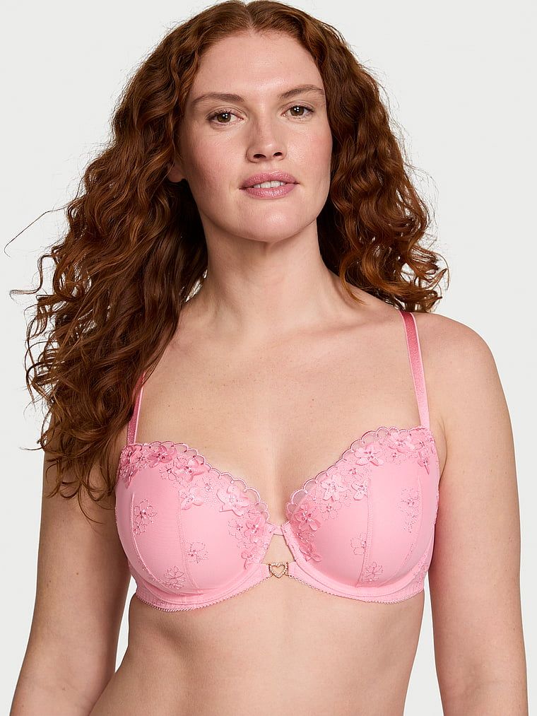Modelka prezentuje biustonosz lekko usztywniany Pretty Petals Demi. Produkt ma kolor różowy i pochodzi z kolekcji Dream Angels.