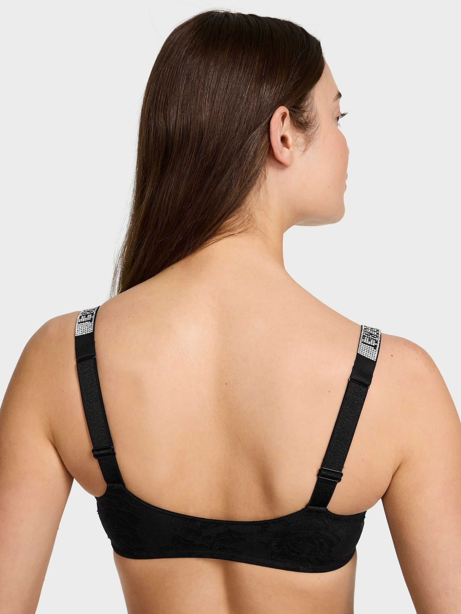 Modelka prezentuje biustonosz koronkowy braletka bez fiszbin z błyszczącymi ramiączkami Shine Strap. Produkt ma kolor czarny i pochodzi z kolekcji Very Sexy.