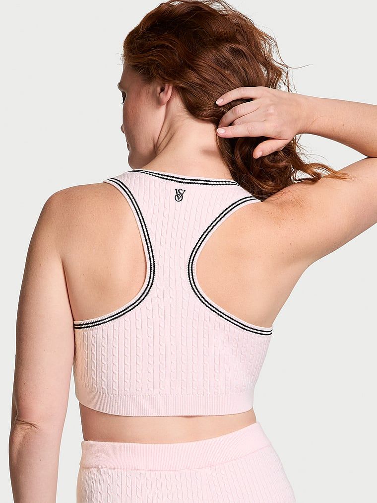 Modelka prezentuje biustonosz braletka top z dzianiny Luxe Cable-Knit. Produkt ma kolor różowy i pochodzi z kolekcji Victoria's Secret.