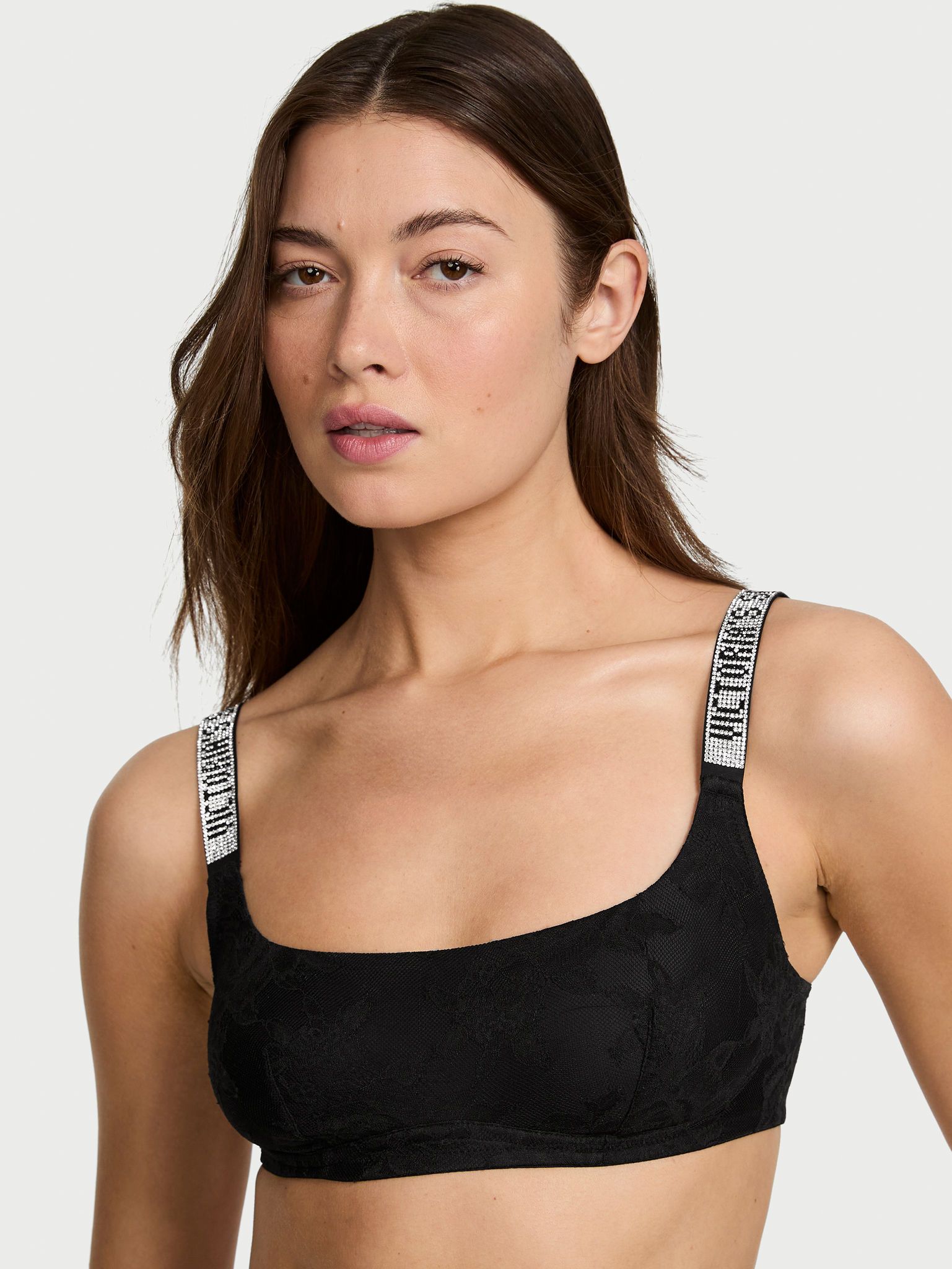 Modelka prezentuje biustonosz koronkowy braletka bez fiszbin z błyszczącymi ramiączkami Shine Strap. Produkt ma kolor czarny i pochodzi z kolekcji Very Sexy.