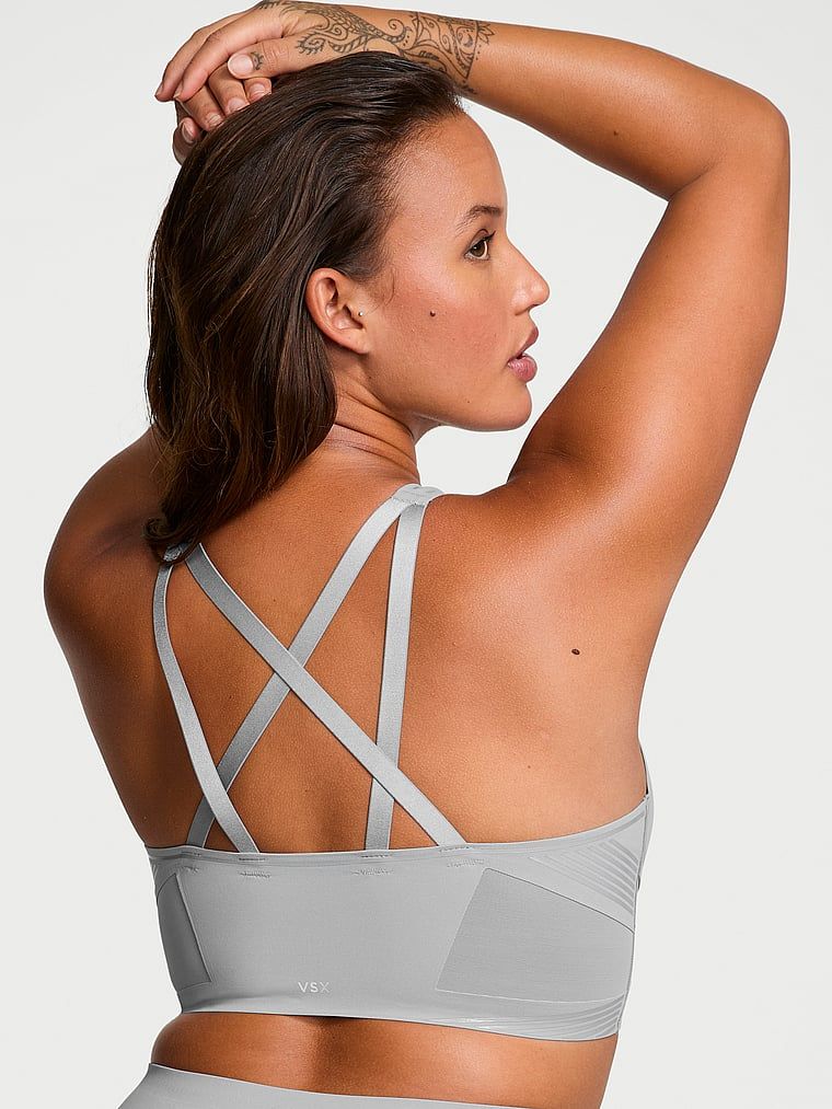 Modelka prezentuje biustonosz sportowy z lekkim wsparciem i dekoltem VSX Elevate Refined Contours. Produkt ma kolor szary i pochodzi z kolekcji VSX.
