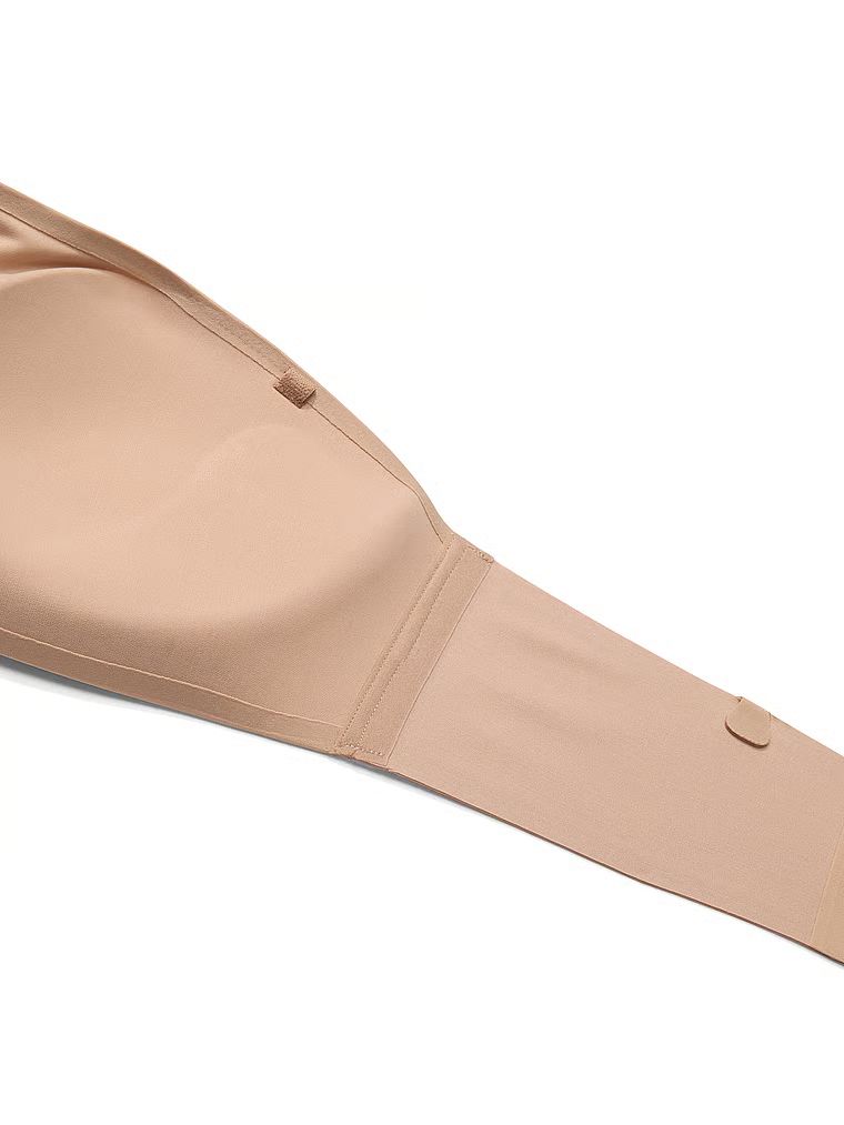 Modelka prezentuje biustonosz push-up bez ramiączek i bez fiszbin Perfect Comfort Strapless. Produkt ma kolor beżowy i pochodzi z kolekcji Victoria's Secret Bare.