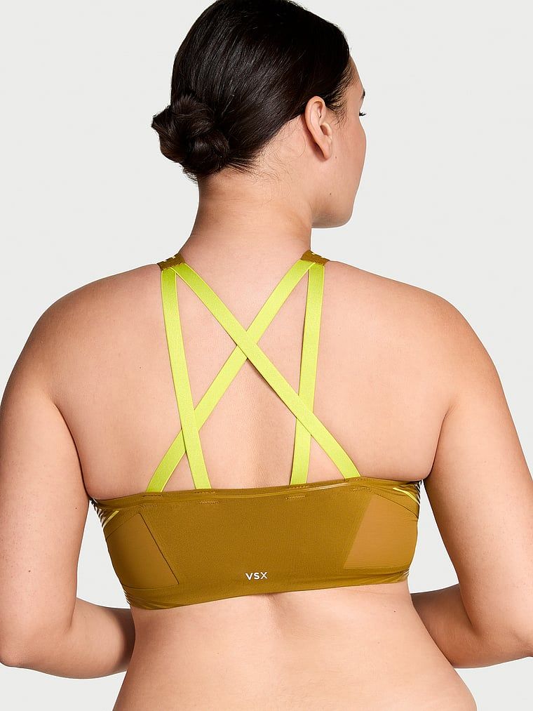 Modelka prezentuje biustonosz sportowy z lekkim wsparciem i dekoltem VSX Elevate Refined Contours. Produkt ma kolor zielony i pochodzi z kolekcji VSX.