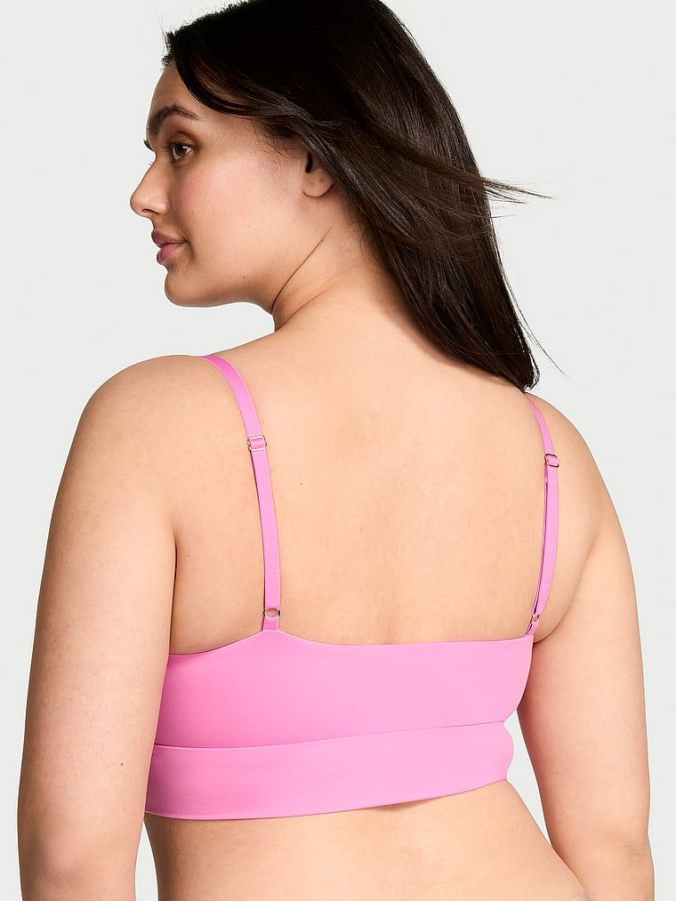 Modelka prezentuje biustonosz braletka Feathersoft Essentials. Produkt ma kolor różowy i pochodzi z kolekcji Victoria's Secret.