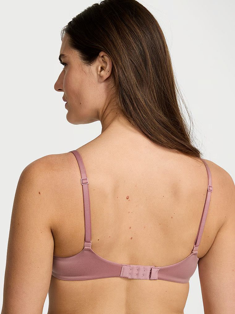 Modelka prezentuje biustonosz lekko usztywniany z mocno zabudowanymi miseczkami. Produkt ma kolor różowy i pochodzi z kolekcji Body by Victoria.