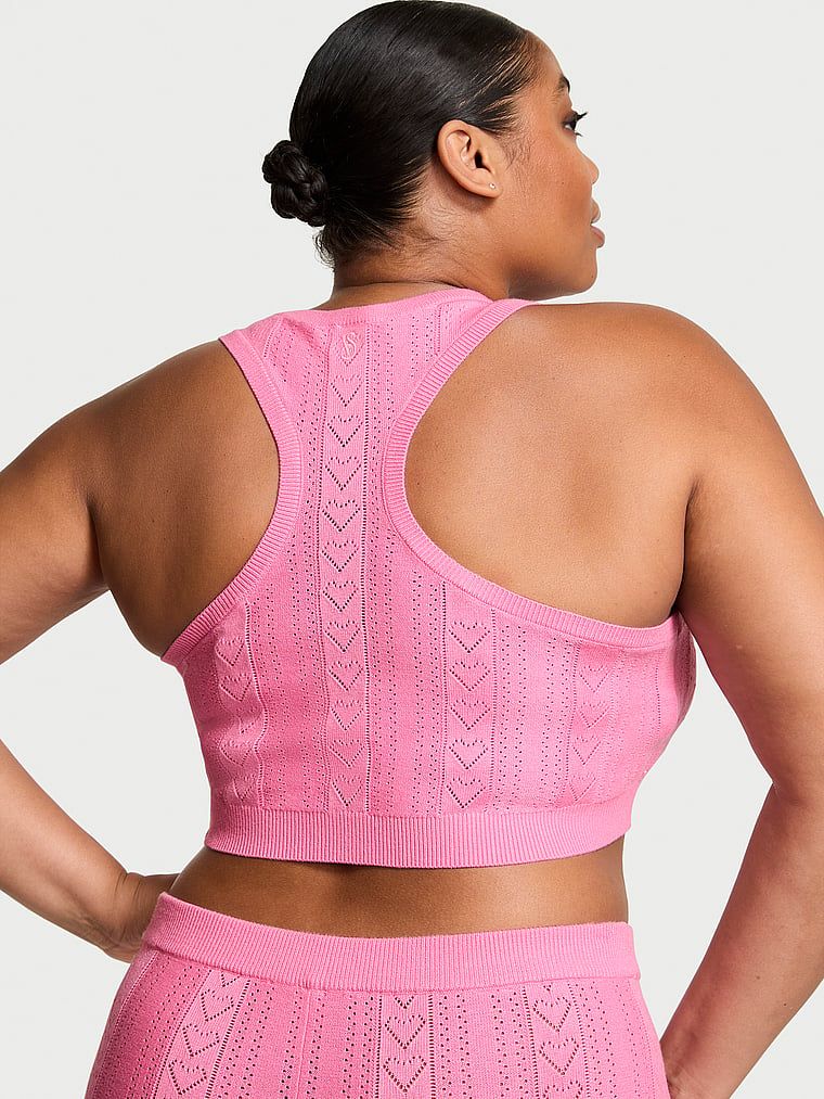 Modelka prezentuje biustonosz braletka z dziurkowanego materiału Luxe Heart Pointelle. Produkt ma kolor różowy i pochodzi z kolekcji Victoria's Secret.