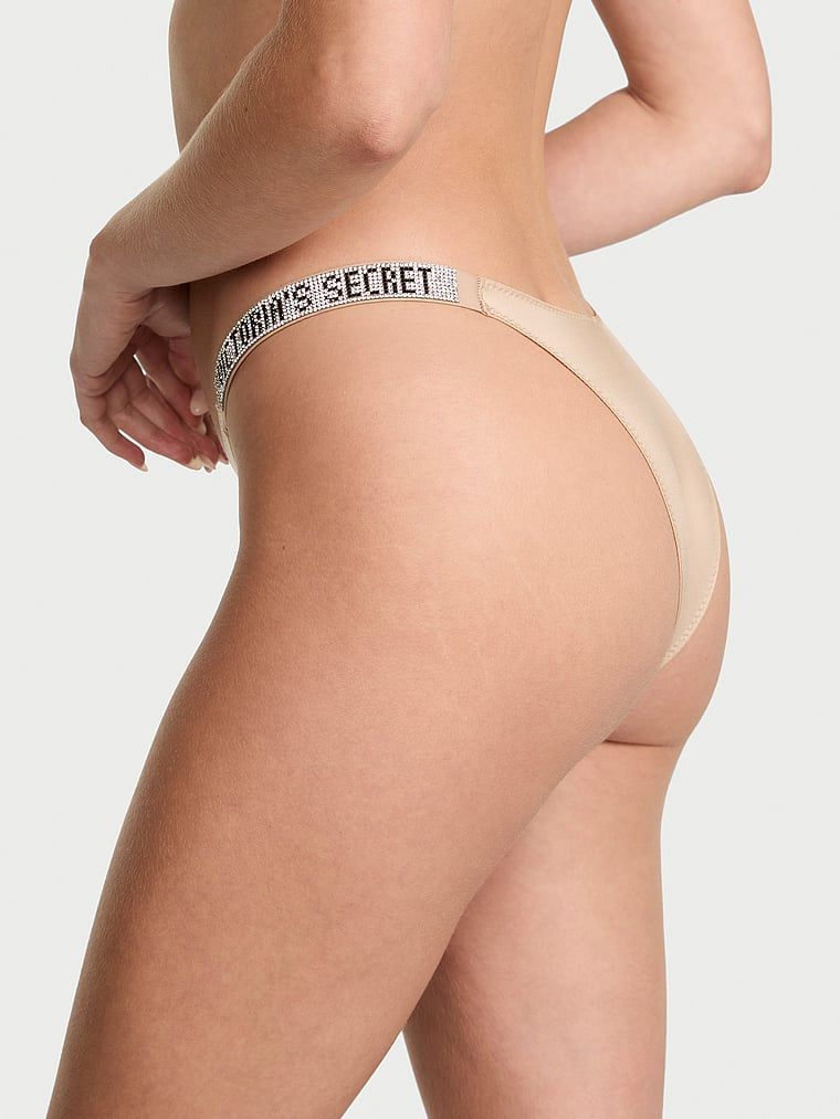Majtki brazyliany z błyszczącymi paskami Shine Strap Brazilian. Produkt ma kolor beżowy i pochodzi z kolekcji Very Sexy. 