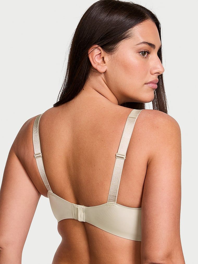 Modelka prezentuje biustonosz push-up powiększający o 2 rozmiary Bombshell Scattered Shine Strap. Produkt ma kolor beżowy i pochodzi z kolekcji Very Sexy.