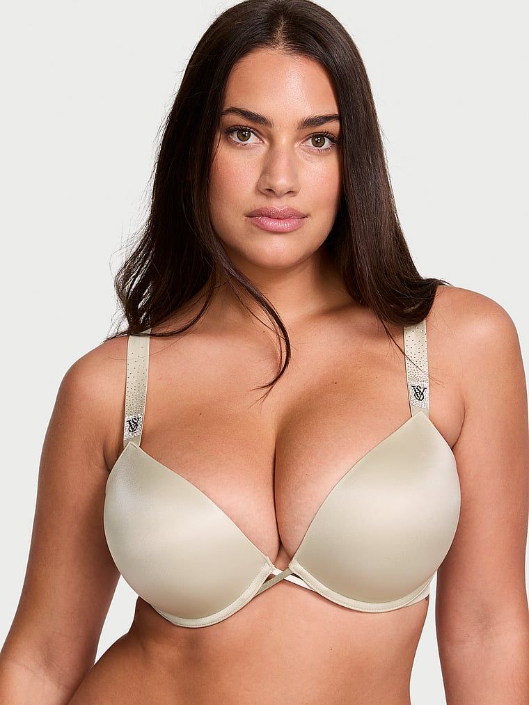 Modelka prezentuje biustonosz push-up powiększający o 2 rozmiary Bombshell Scattered Shine Strap. Produkt ma kolor beżowy i pochodzi z kolekcji Very Sexy.