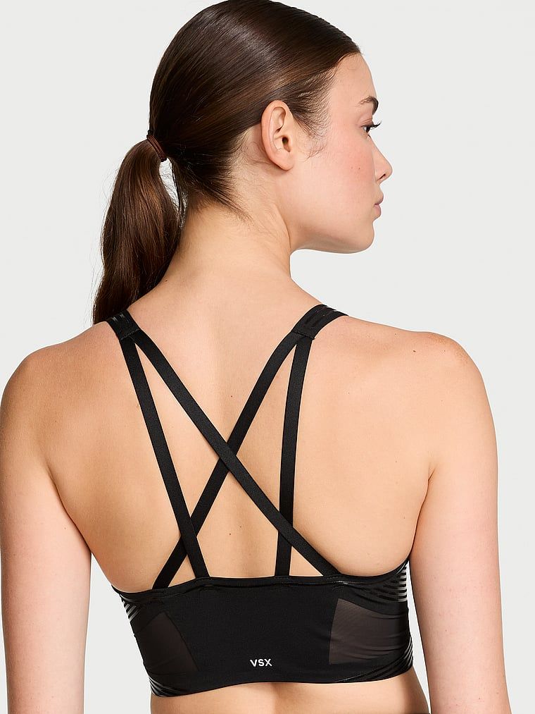 Modelka prezentuje biustonosz sportowy z lekkim wsparciem i dekoltem VSX Elevate Refined Contours. Produkt ma kolor czarny i pochodzi z kolekcji VSX.