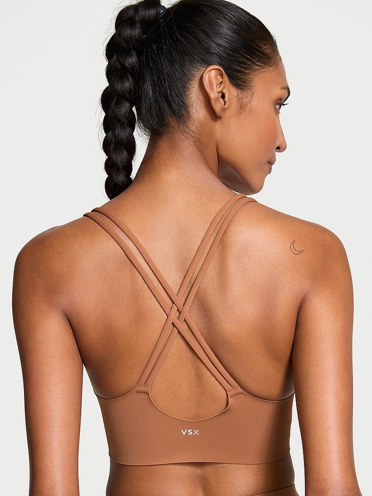 Modelka prezentuje biustonosz sportowy z lekkim wsparciem Elevate Strappy. Produkt ma kolor brązowy i pochodzi z kolekcji VSX.