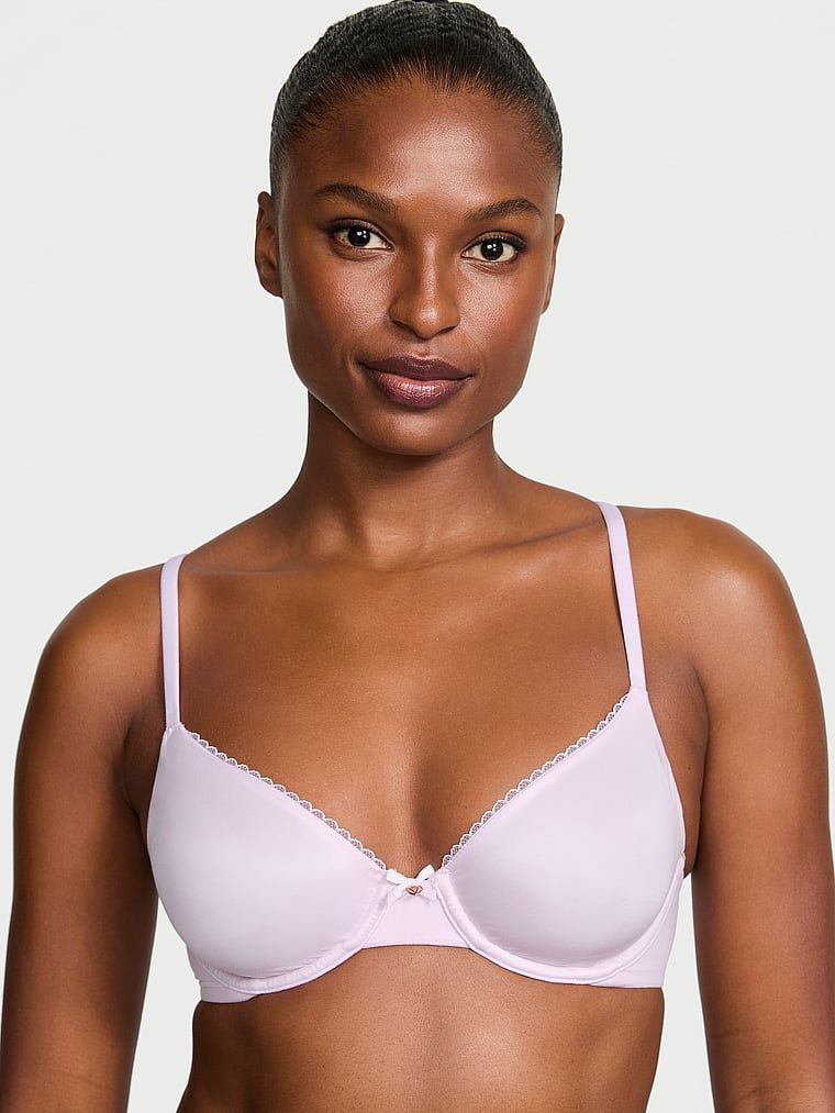 Modelka prezentuje biustonosz nieusztywniany Invisible Lift Smooth Demi. Produkt ma kolor purpurowy i pochodzi z kolekcji Body by Victoria.