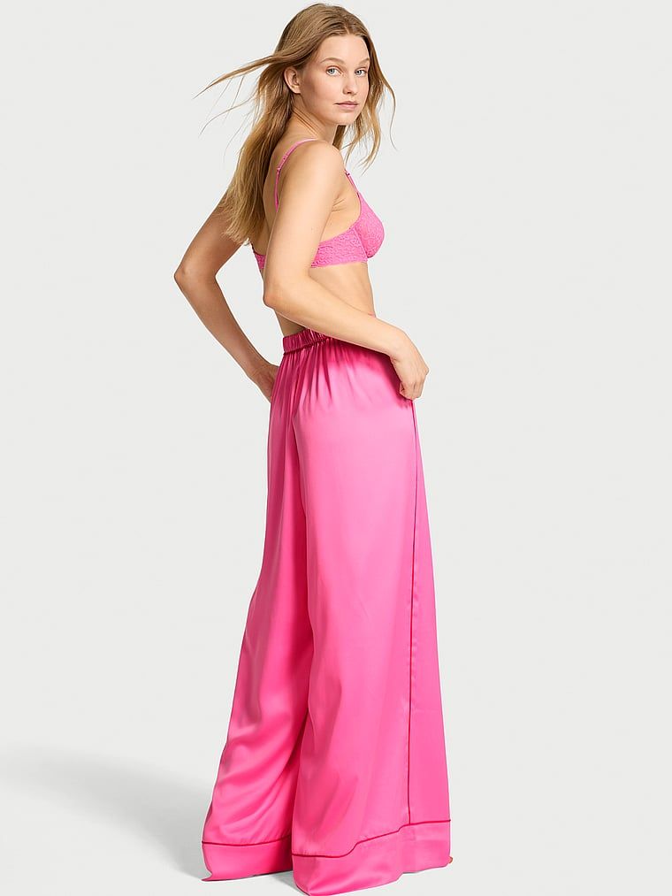 Spodnie satynowe do spania szerokie. Produkt ma kolor różowy i pochodzi z kolekcji Victoria's Secret. 